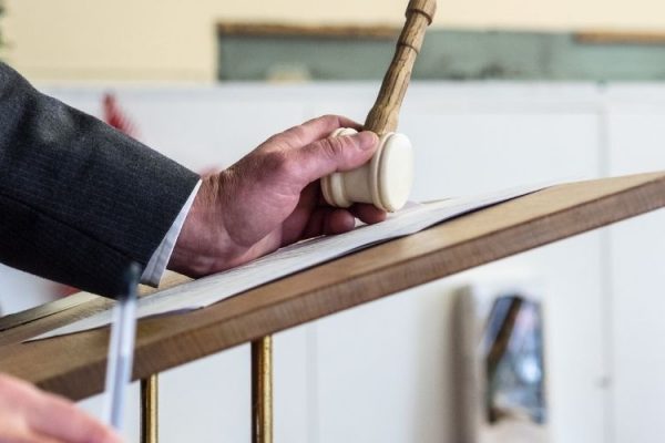 Auctioneer holding hammer and taking bids
