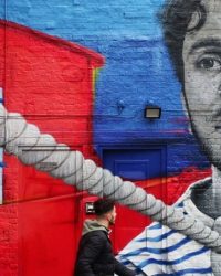 Street Art alongside Regents Canal featuring a man pulling a canal barge by Zabou