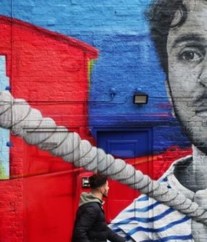 Street Art alongside Regents Canal featuring a man pulling a canal barge by Zabou